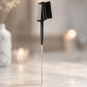 May include: A black 3-in-1 precision tool featuring a fine-toothed comb and a dense brush head on one end, connected to a slender, textured silver metal handle that tapers to a point. The text Tinsel 3-in-1 Precision Tool is printed below.