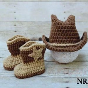 May include: A crochet set featuring a cowboy hat and boots in shades of brown and tan. The boots have a star applique. The hat is perched on a ball of white yarn. The text "KrazyHa" and "NR.1" are visible.