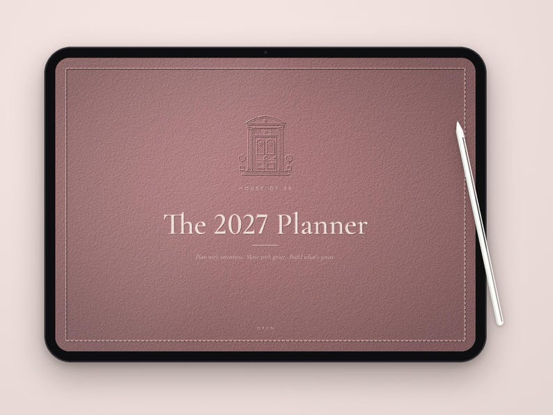 May include: A digital tablet displaying a mauve-colored planner interface titled The 2027 Planner. The screen features a line-art icon of a doorway, the text House of 22, and the phrase Plan with intention. Make your goals. Build what's yours. A stylus rests on the right side.
