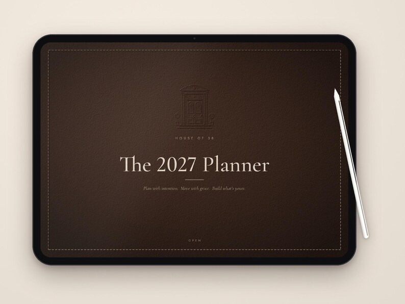 Puede incluir: Una tableta digital de color marr&oacute;n oscuro que muestra The 2027 Planner con un l&aacute;piz &oacute;ptico blanco en el lado derecho. La pantalla presenta un icono de puerta, el texto House of SB, The 2027 Planner, Plan with intention. Move with grace. Build what's yours, y OPEN.