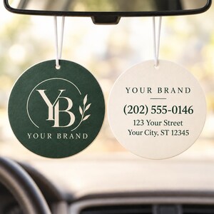 May include: Two circular hanging air fresheners. The left one is dark green with a white YB logo, a leaf graphic, and the text YOUR BRAND. The right one is white with the text YOUR BRAND, (202) 555-0146, 123 Your Street, Your City, ST 12345.