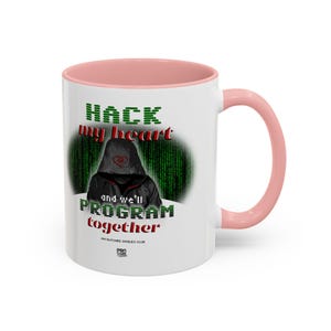 May include: A white ceramic mug with a light pink interior and handle. The front features a graphic of a hooded figure against a green digital matrix background, with the text HACK my heart and we'll PROGRAM together and GLITCHED SINGLES CLUB.