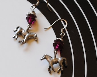 May include: A pair of silver horse earrings with dangling purple crystal beads.