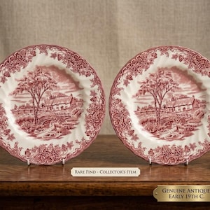 Può includere: Due piatti in ceramica con un motivo a trasferimento rosso e bianco raffigurante un cottage, un ponte e alberi. I bordi smerlati sono decorati con motivi floreali. Il testo sull'immagine recita: RARE FIND - COLLECTOR'S ITEM e GENUINE ANTIQUE, EARLY 19TH C.