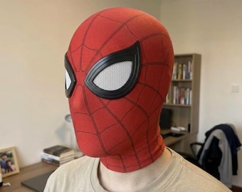 May include: A red fabric mask featuring a black web pattern across the surface. The mask includes two large, almond-shaped eye lenses outlined in black with a white mesh texture covering the eye openings, designed to cover the entire head.