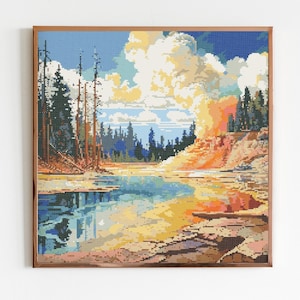 May include: A framed cross-stitch artwork depicting a colorful landscape with a river, trees, and a rocky cliff. The sky is blue with white clouds. The colors are vibrant and the scene is peaceful.