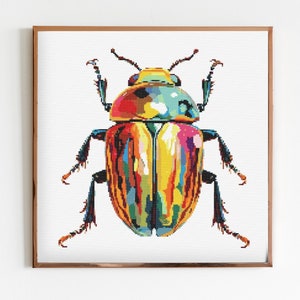 May include: A colourful, abstract beetle with a yellow, red, green and blue pattern. The beetle is framed in a gold frame.