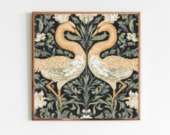 Op de afbeelding: Een ingelijst wandtapijt met twee gestileerde vogels met lange nek en uitgespreide vleugels, die elkaar aankijken. De vogels zijn licht oranje van kleur met witte accenten. De achtergrond is een donkergroen en zwart bloemenpatroon.