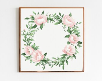 May include: A framed floral print depicting a wreath of pink peonies and green foliage. The watercolour-style artwork is set against a white background, creating a soft and elegant aesthetic. The frame is a warm brown colour.