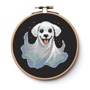 May include: A white dog wearing a ghost costume with a black background. The dog is smiling and has a white ghost sheet around it.