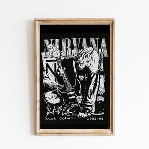 Puede incluir: Impresión enmarcada en blanco y negro de un músico tocando una guitarra con la palabra "NIRVANA" y el texto "kurt cobain 1992-94" debajo.