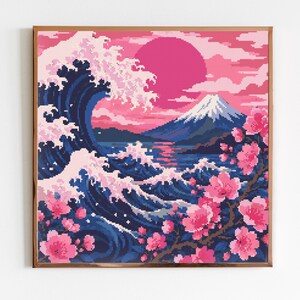 May include: A square framed pixel art print featuring a large dark blue ocean wave with white foam, a snow-capped mountain in the distance, and a bright pink sun in a pink sky. A branch with pink cherry blossoms extends across the foreground.