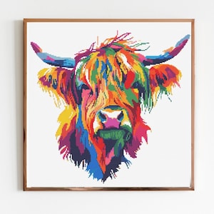 May include: A colorful pop art style print of a Highland cow's head. The artwork features a vibrant palette of blues, greens, yellows, and pinks, creating a striking visual effect. The image is framed in a brown wooden frame.