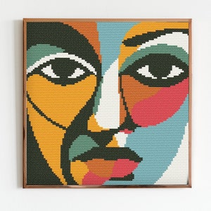 May include: A framed abstract painting of a face with a colorful geometric design. The face is made up of shades of yellow, orange, green, blue, pink, and white.