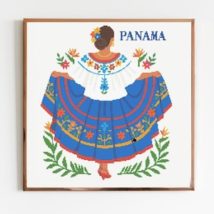 Könnte beinhalten: Gerahmte Illustration einer Frau in traditioneller panamaischer Tracht. Das Kleid ist blau und weiß mit floralen und geometrischen Mustern. Das Wort "PANAMA" steht oben. Grüne Blätter und Blumen umgeben die Figur.