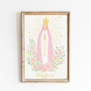 Puede incluir: Impresión enmarcada que presenta una ilustración religiosa de una figura con velo rosa y corona dorada, rodeada por un halo y elementos florales. El texto "Pray for us" está en la parte inferior. El marco es de color marrón claro.