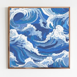 Op de afbeelding: Een ingelijst kruissteekkunstwerk met een blauw en wit golfpatroon. De golven zijn gestileerd en abstract, wat een dynamisch en modern ontwerp creëert.