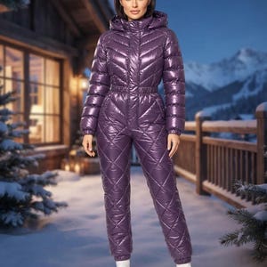 Könnte beinhalten: Ein glänzender, violetter, gesteppter Schneeanzug mit Kapuzenkragen, Frontreißverschluss und langen Ärmeln mit elastischen Bündchen. Das Oberteil hat eine Chevron-Steppung, während die Hose ein Rautensteppmuster aufweist.