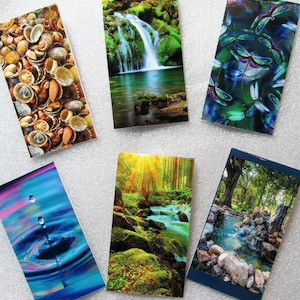 May include: Six different nature-themed bookmarks with various images, including a waterfall, a forest, a stream, a pond, seashells, and dragonflies.