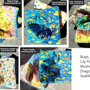 May include: Set of 6 colorful fabric pot holders with various designs featuring bugs, frogs, lily pads, mushrooms, dragonflies, and sea life. The pot holders are reversible and have a quilted texture.