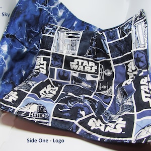 May include: A blue and black fabric square with a Star Wars pattern on one side and a blue and white lightning bolt pattern on the other side. The fabric square has the text "Star Wars" printed on it.