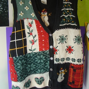 May include: A sleeveless knit vest featuring a patchwork design with various holiday motifs including snowmen, a Christmas tree, hearts, and snowflakes. The vest has a black button-down front, a V-neckline, and a mix of red, green, white, and black colors.