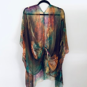 K&ouml;nnte beinhalten: Ein durchsichtiges Kimono mit braunen, gr&uuml;nen und orangen Mustern und einem Bindeverschluss.