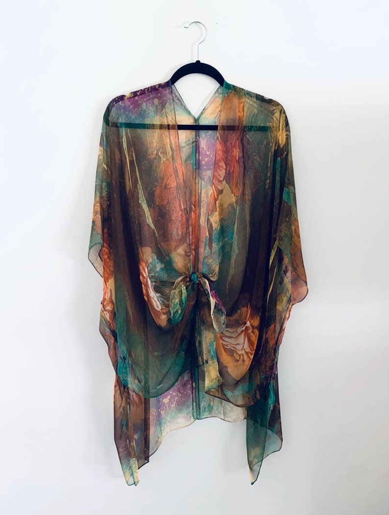 K&ouml;nnte beinhalten: Ein durchsichtiges Kimono mit braunen, gr&uuml;nen und orangen Mustern und einem Bindeverschluss.
