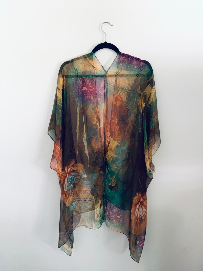 K&ouml;nnte beinhalten: Ein durchsichtiges Kimono mit floralem Muster in Braun, Gr&uuml;n und Lila mit V-Ausschnitt.
