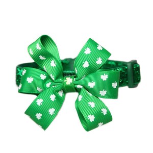 May include: Green glitter pet collar with a green shamrock patterned bow. The bow is tied in a knot and has white shamrocks.