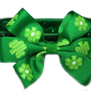 May include: Green glitter dog collar with a green shamrock bow. The bow has white shamrocks printed on it.