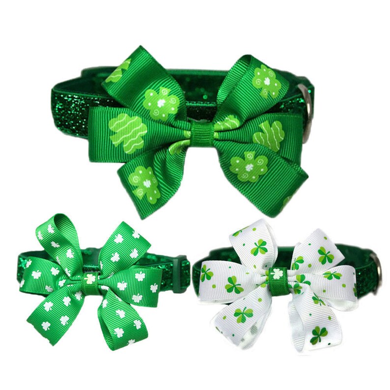 May include: Three green glitter dog collars with shamrock print bows. The bows are tied in a bow shape. The collars are for small dogs.