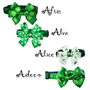 May include: Four green and white dog collars with shamrock and polka dot patterned bows. The collars are labeled "Afric", "Alva", "Alice", and "Aideen".