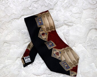 May include: A black silk tie with a red, gold, and blue patterned design. The pattern features a repeating design of stylized stamps.