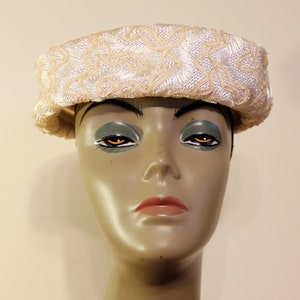 May include: A white hat with a delicate floral design. The hat is made of a soft, textured fabric and has a wide brim.