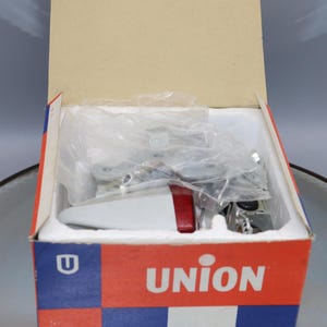 K&ouml;nnte beinhalten: Ein wei&szlig;er und roter Spielzeug-LKW in einem Karton mit dem Wort "UNION" auf der Vorderseite. Der Karton ist ge&ouml;ffnet und der LKW ist teilweise im Inneren sichtbar.