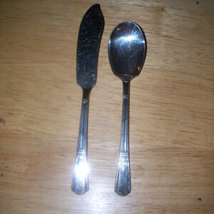 Peut inclure: Un couteau à beurre en argent et une cuillère à café en argent avec des manches ornés.