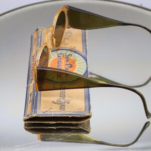 Op de afbeelding: Een witte keramische mok met een zwart handvat en de tekst "But First, Coffee" in een zwarte, vette letter. De mok staat op een wit oppervlak. De mok is ongeveer 10 cm hoog.
