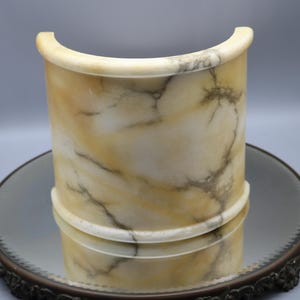 May include: A curved, half-round alabaster lamp base with a white and yellow marbled pattern.