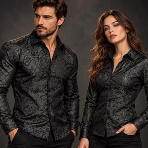 May include: Two long-sleeved button-down shirts in black with a tonal, intricate paisley jacquard pattern. Each shirt features a classic collar, a front button placket, and fitted cuffs, showcasing a consistent dark, textured fabric design.