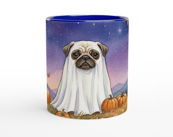 May include: A ceramic mug with a deep blue interior featuring a graphic of a pug wearing a white ghost costume. The scene includes orange pumpkins on the ground and a purple night sky with stars in the background, creating a festive autumn theme.