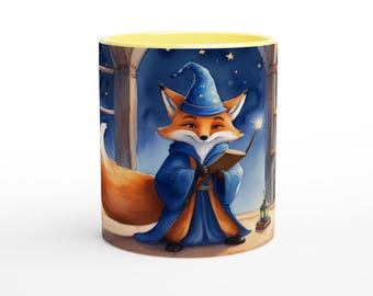 May include: A ceramic mug with a yellow interior and rim, featuring a printed illustration of an orange fox wearing a blue wizard hat and robe. The fox holds a book and a glowing wand against a dark blue night sky background with stars.