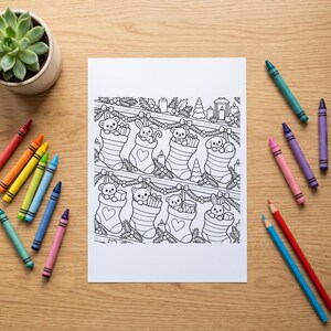 May include: A white rectangular colouring page featuring black line art of Christmas stockings hung on a mantel, each containing a different animal character, surrounded by holiday greenery, candles, and gifts, with scattered colourful crayons.
