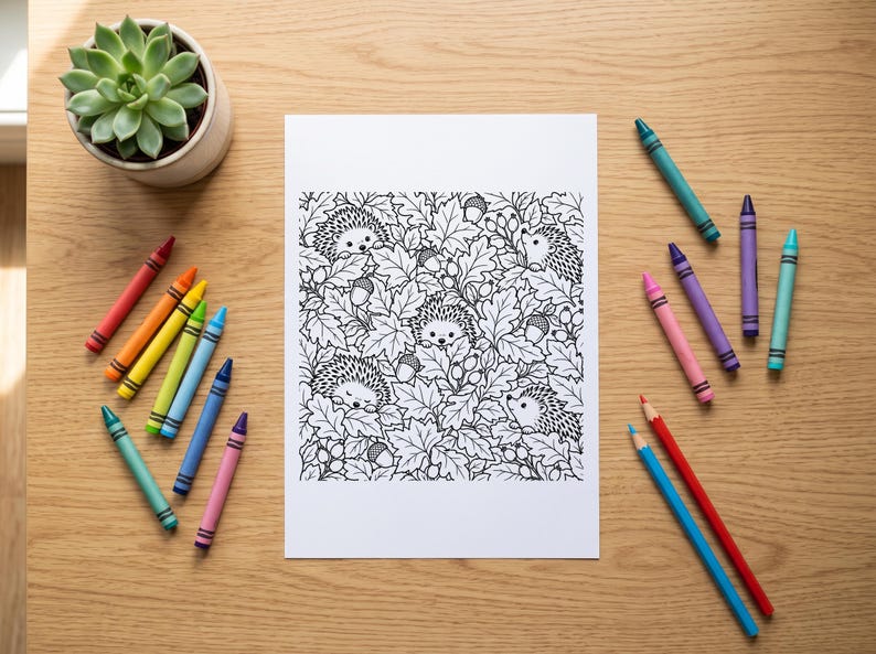 Puede incluir: Una p&aacute;gina para colorear rectangular blanca con una ilustraci&oacute;n detallada en blanco y negro de varios erizos escondidos entre hojas de roble y bellotas, rodeada por un surtido de crayones de colores sobre una superficie de madera.