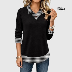 May include: A black long-sleeve top featuring a V-neck collar, cuffs, and a bottom hem layered with a black and white houndstooth pattern. The top is paired with blue denim jeans, creating a layered appearance with a classic contrasting design.