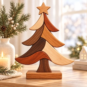 May include: A decorative wooden Christmas tree sculpture composed of interlocking curved segments in varying shades of light, medium, and dark wood. The tree is topped with a five-pointed star and stands on a rectangular wooden base.