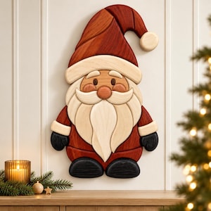 Può includere: Una decorazione da parete in legno a forma di Babbo Natale, caratterizzata da un cappello rosso scuro con un pon-pon in legno chiaro, barba e baffi color crema, un cappotto rosso, muffole nere e stivali neri, realizzata con strati di legno.