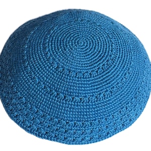 Peut inclure: Une kippa crochetée bleu vif présentant un motif circulaire de mailles serrées rayonnant depuis le centre, accentué par des anneaux concentriques de nœuds texturés en relief et une bordure ajourée plus large à la base.