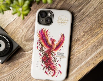 Könnte beinhalten: Eine weiße Smartphone-Hülle mit einer farbenfrohen Phönix-Illustration in Pink, Orange und Violett. Das Design zeigt eine Kette, florale Akzente, den Schriftzug "HINFALLEN. AUFSTEHEN. WEITERMACHEN." sowie ein kreisförmiges Logo.