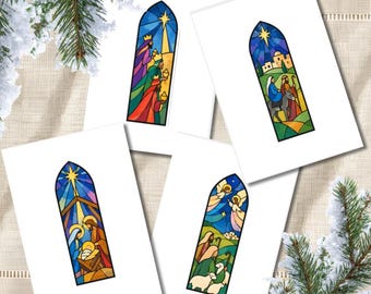 May include: Four white greeting cards featuring colourful stained glass style illustrations of the Nativity scene. Each card displays a different arched window design depicting figures, a star, and landscape elements in vibrant blue, red, and green.